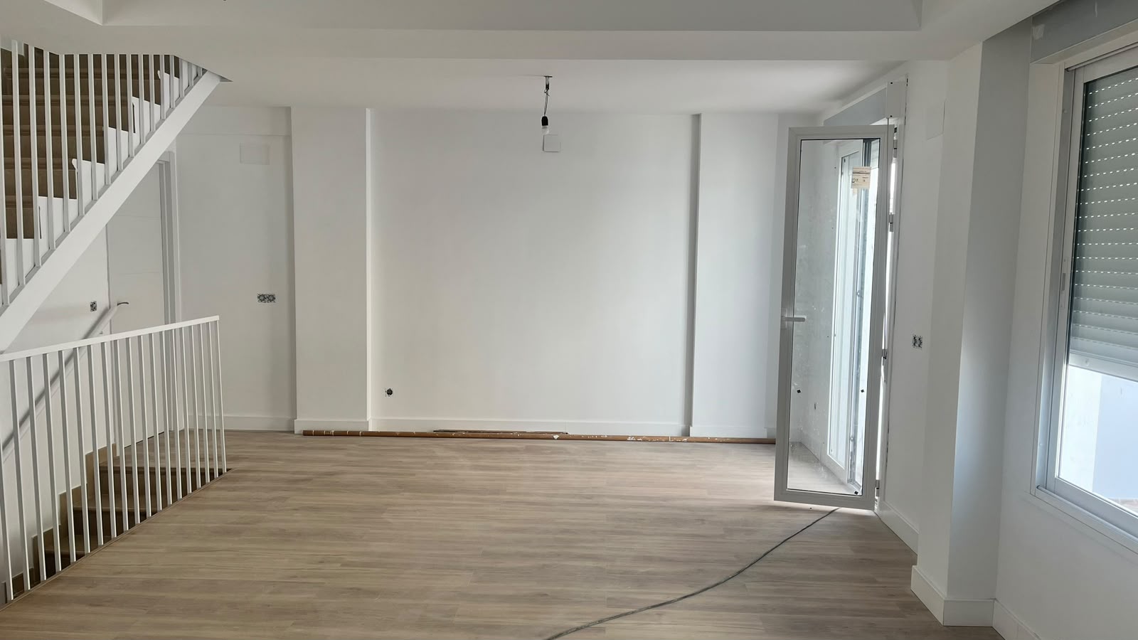 Salón con escalera y ventanales