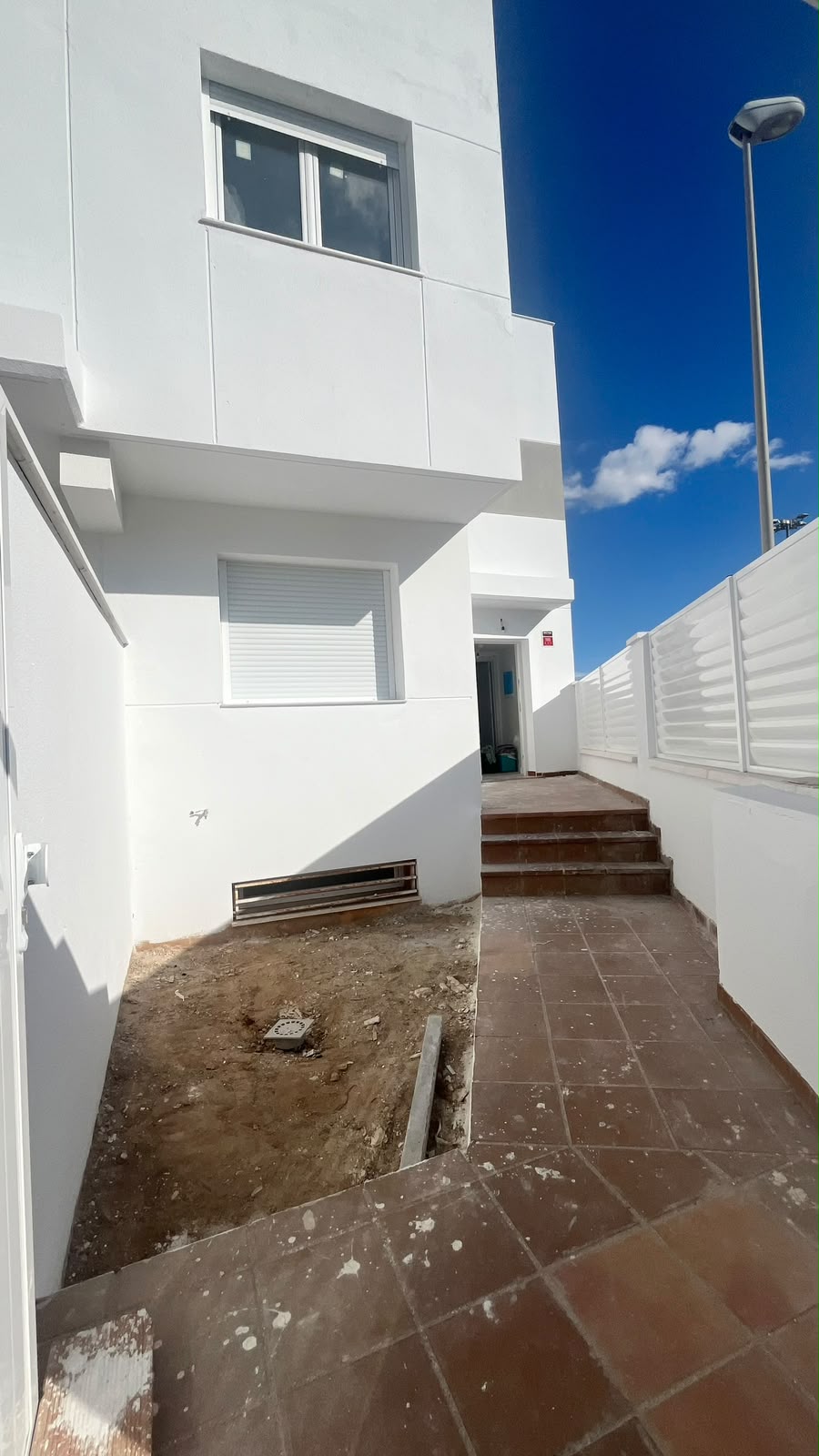 Patio lateral con vallado blanco